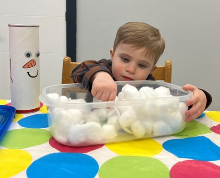 Child playing in cotton ball snow